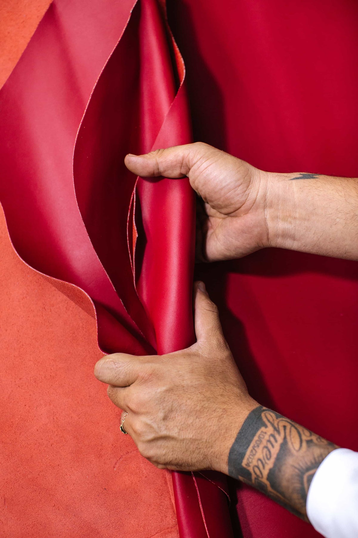Hands holding a roll of red leather