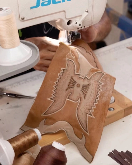 Honey-colored boot shaft with the embroidered phoenix, at a sewing machine
