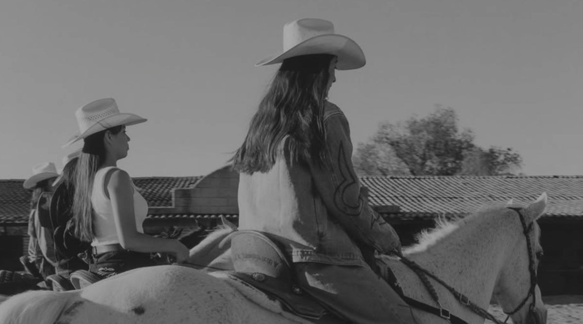Mujeres con sombrero vaquero montando a caballo en un rancho, en blanco y negro